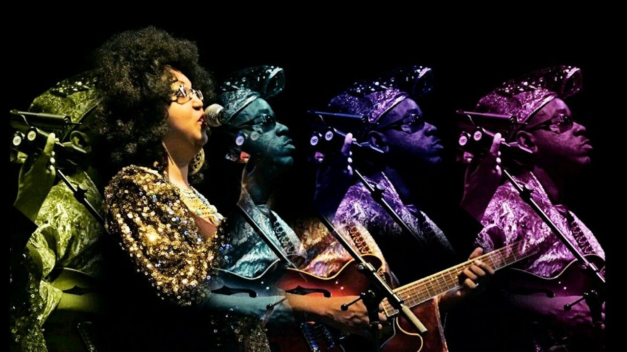  Musicians of Afrofuturist group Jupiter Blue sing and play guitar. The image has been photoshopped to replicated the guitar player four times in different shades of purple, blue, and green.