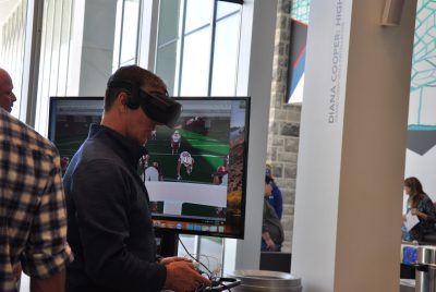 A man wears a virtual reality headset and holds a game controller.