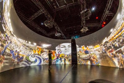 A person stands in the center of the Cyclorama, a 360 degree projection system located in the Cube.