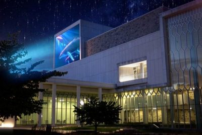 A rendering of the Moss Arts Center shows a colorful projection on display on the side of the building.