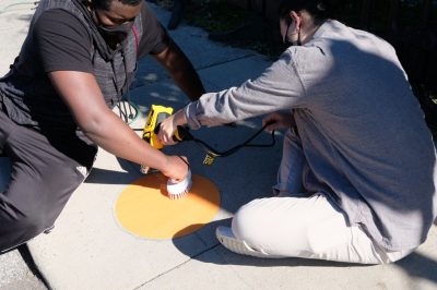 Students install orange circles, as part of the Hokie Circles project, on Blacksburg sidewalks to encourage physical distancing. Photo courtesy of Aki Ishida.