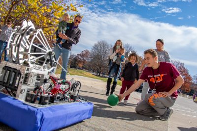 The Copperhead Robotics team student demonstrates how to play ball with a robot during the 2023 Virginia Tech Science Festival. Photo by Rodney Kimbangu for Virginia Tech.