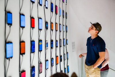 Visitors look wall with discarded phones that still contain personal information.